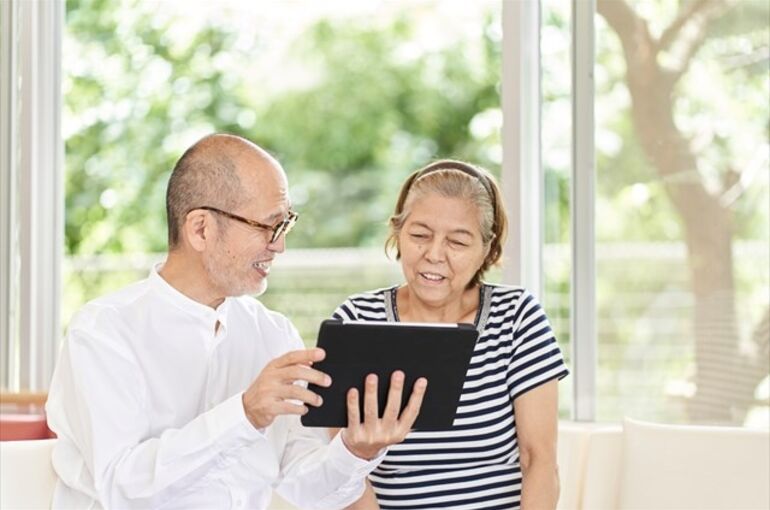 タブレットを見る夫婦